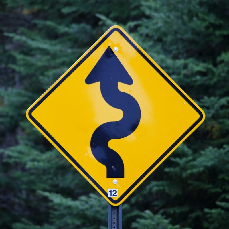 A yellow and black warning chevron sign
